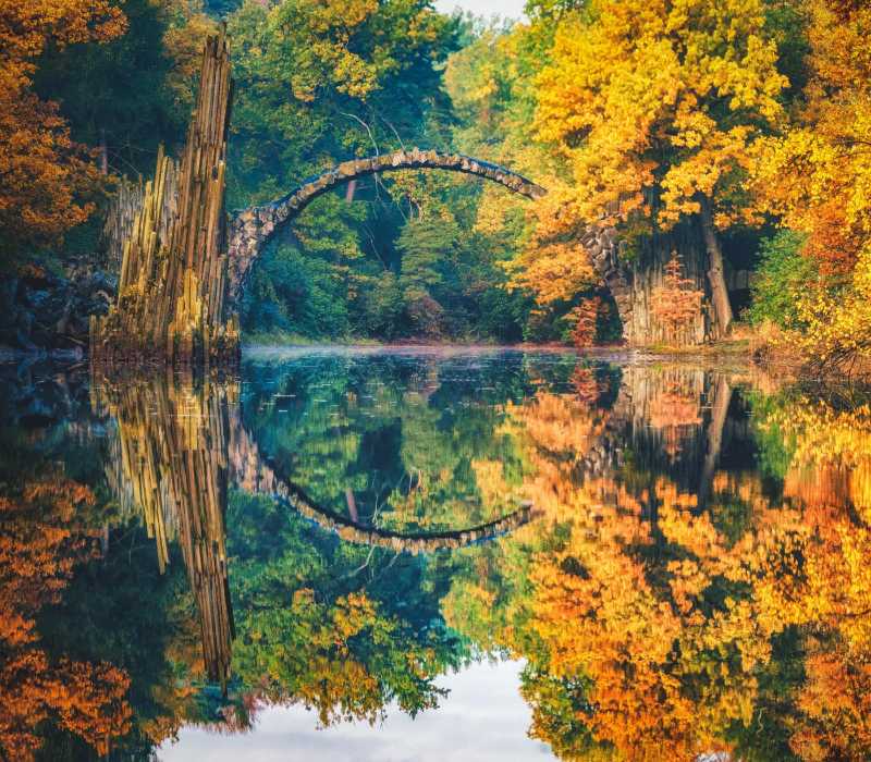 Reflet de l'arche et des arbres dans le lac