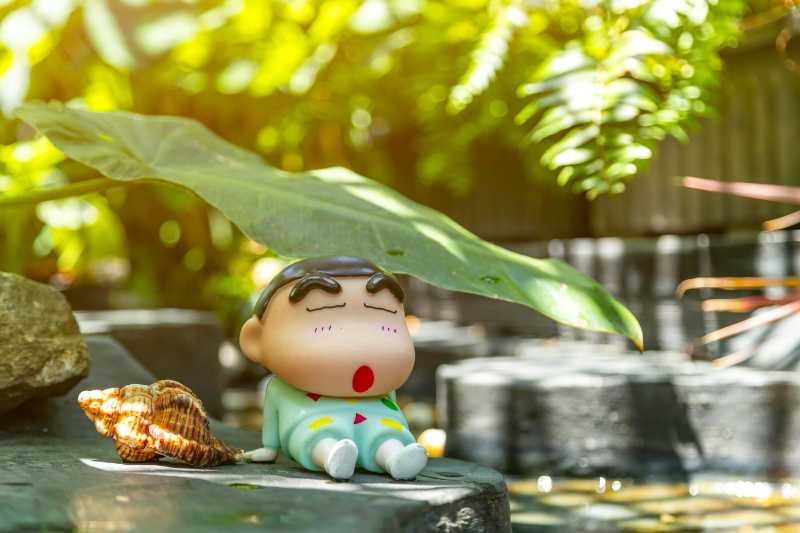 Relaxed Cartoon Figurine with Seashell Outdoors