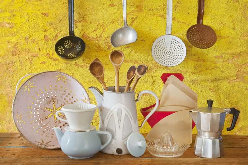 Rustic kitchen still life with vintage utensils against a vibrant yellow wall