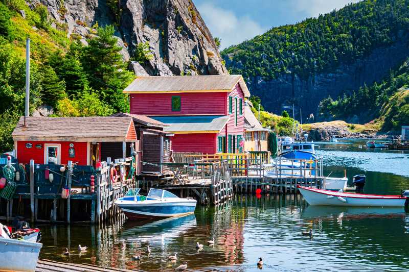 small boats are docked in quidi vidi harbor in st johns newfoundland and reflected in the quiet waters there
