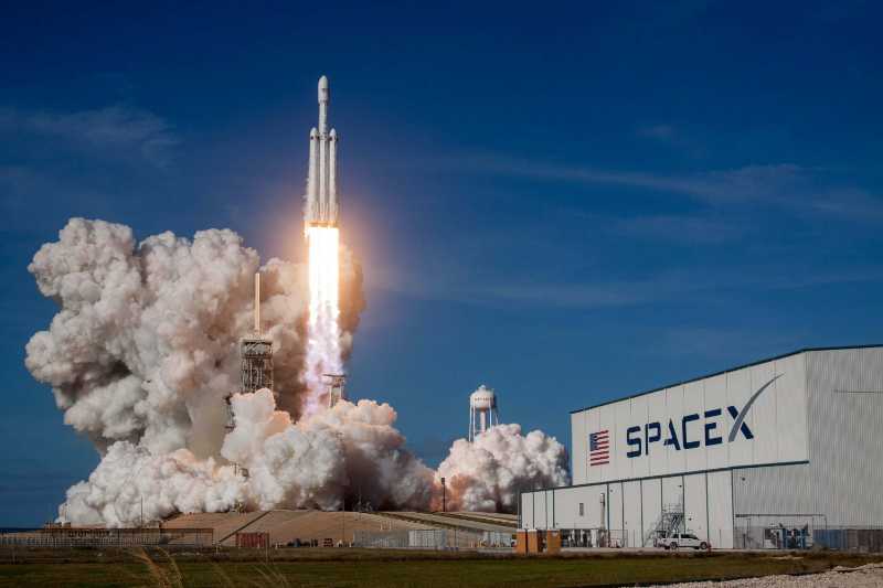 SpaceX Falcon Heavy Rocket Launch with Massive Plume and Hangar
