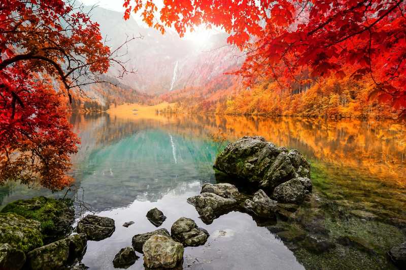 Stunning autumn lake landscape with vibrant red and orange trees