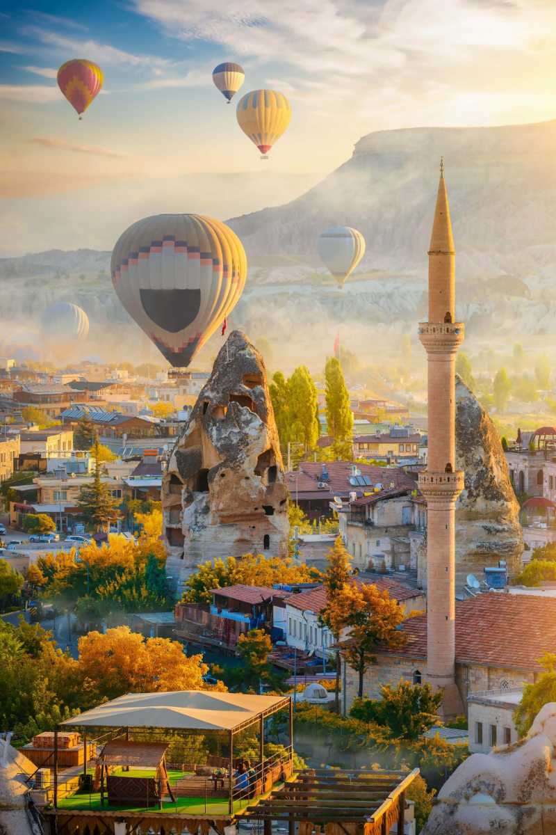 Sunrise landscape with hot air balloons and mosque in Goreme Cappadocia