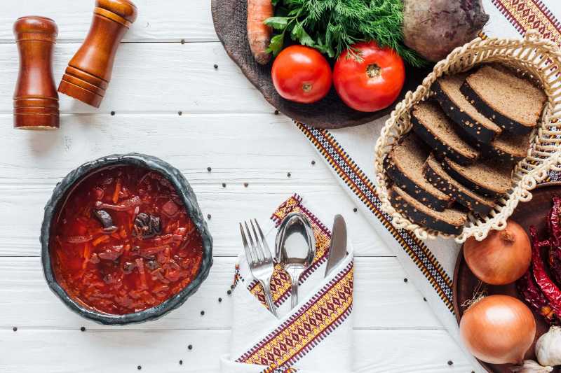 Ingredientes tradicionais para sopa de beterraba talheres fundo de madeira branca