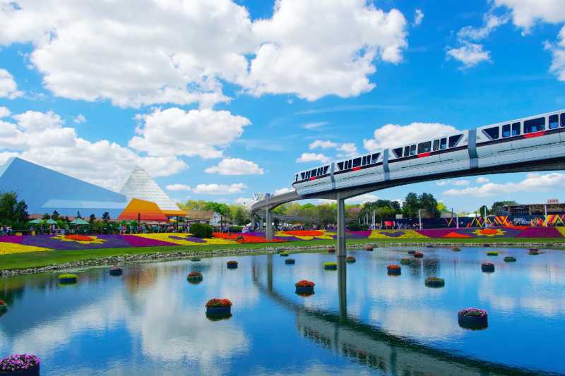 train crosses the lake under blue sky during daytime - jigsaw puzzle