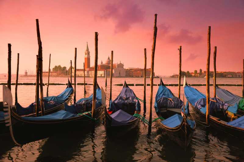 Venice with famous gondolas at gentle pink sunrise light