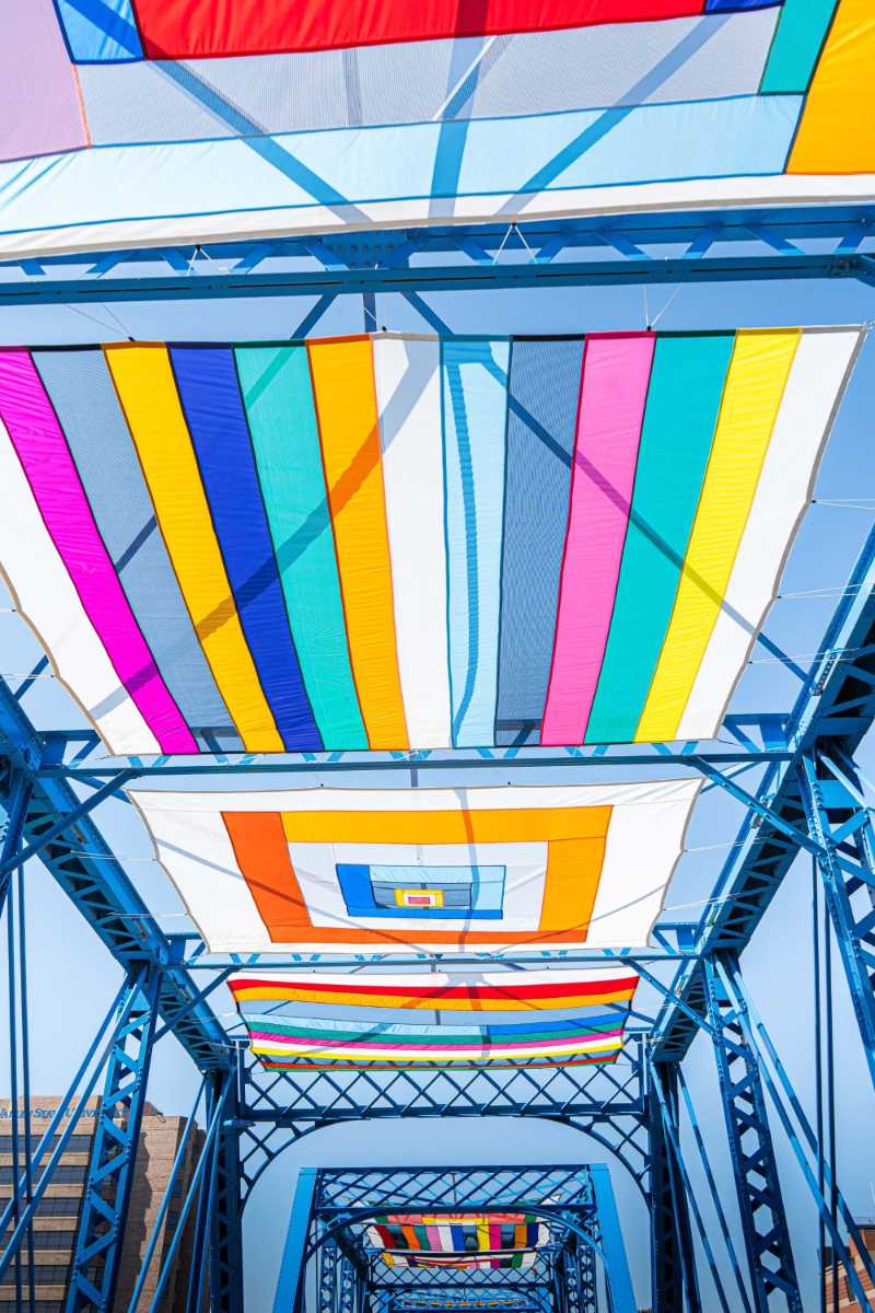 vibrant colorful canopy installation on blue bridge