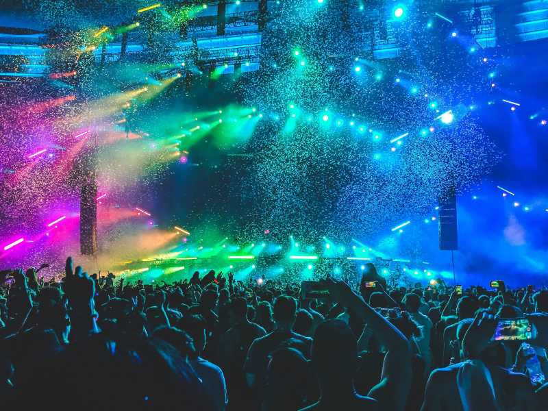 Vibrant Music Festival Crowd with Confetti and Stage Lights