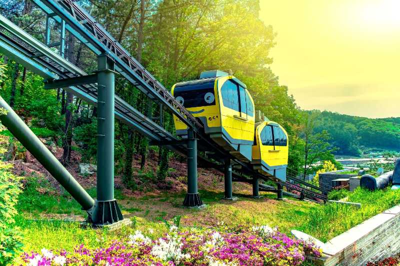 Yellow Monorail Train on a Track in a Scenic Park