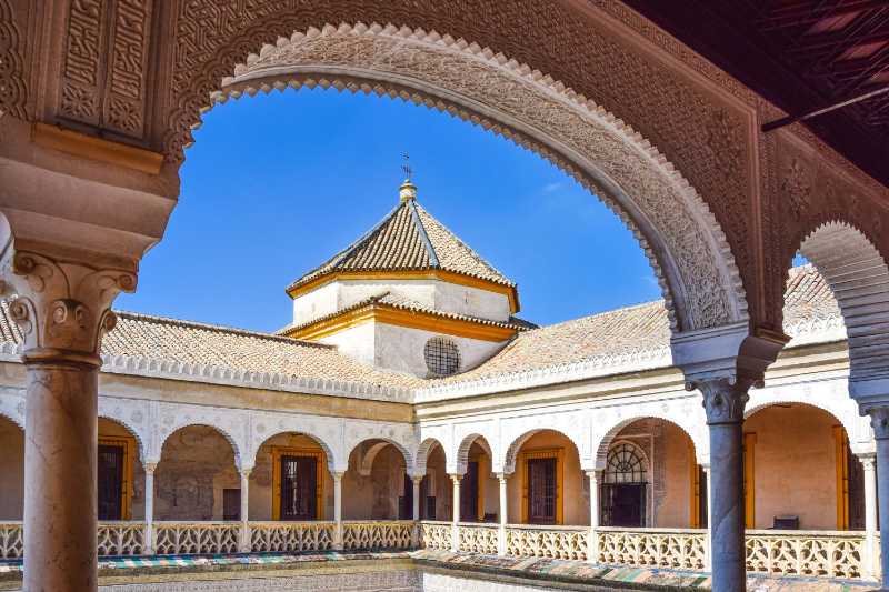View of the ornate arches and courtyard of Casa de Pilatos in Seville