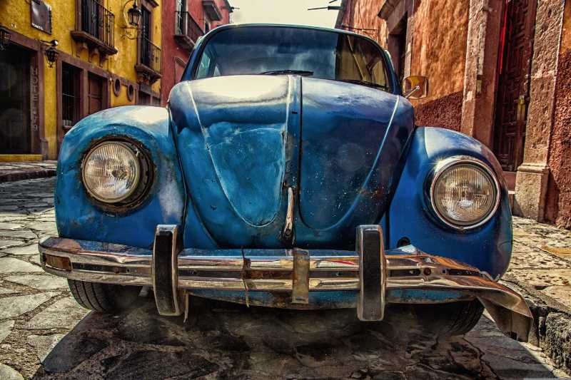 Vintage Blue Volkswagen Beetle on a Colorful Cobblestone Street