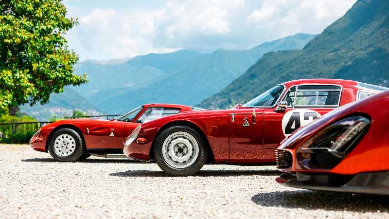 Autos deportivos rojos antiguos en una montaña escénica