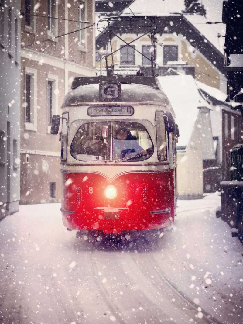 Vintage Red Tram in Heavy Snowfall on European Street