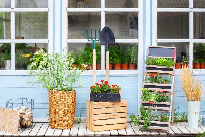 Wooden porch of house with plants garden tools