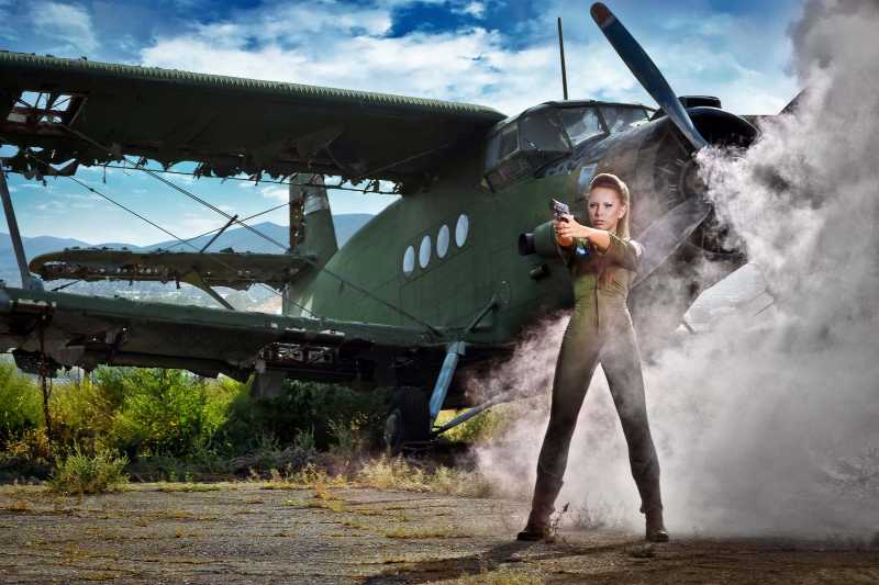 Jeune femme près de l'avion avec des armes